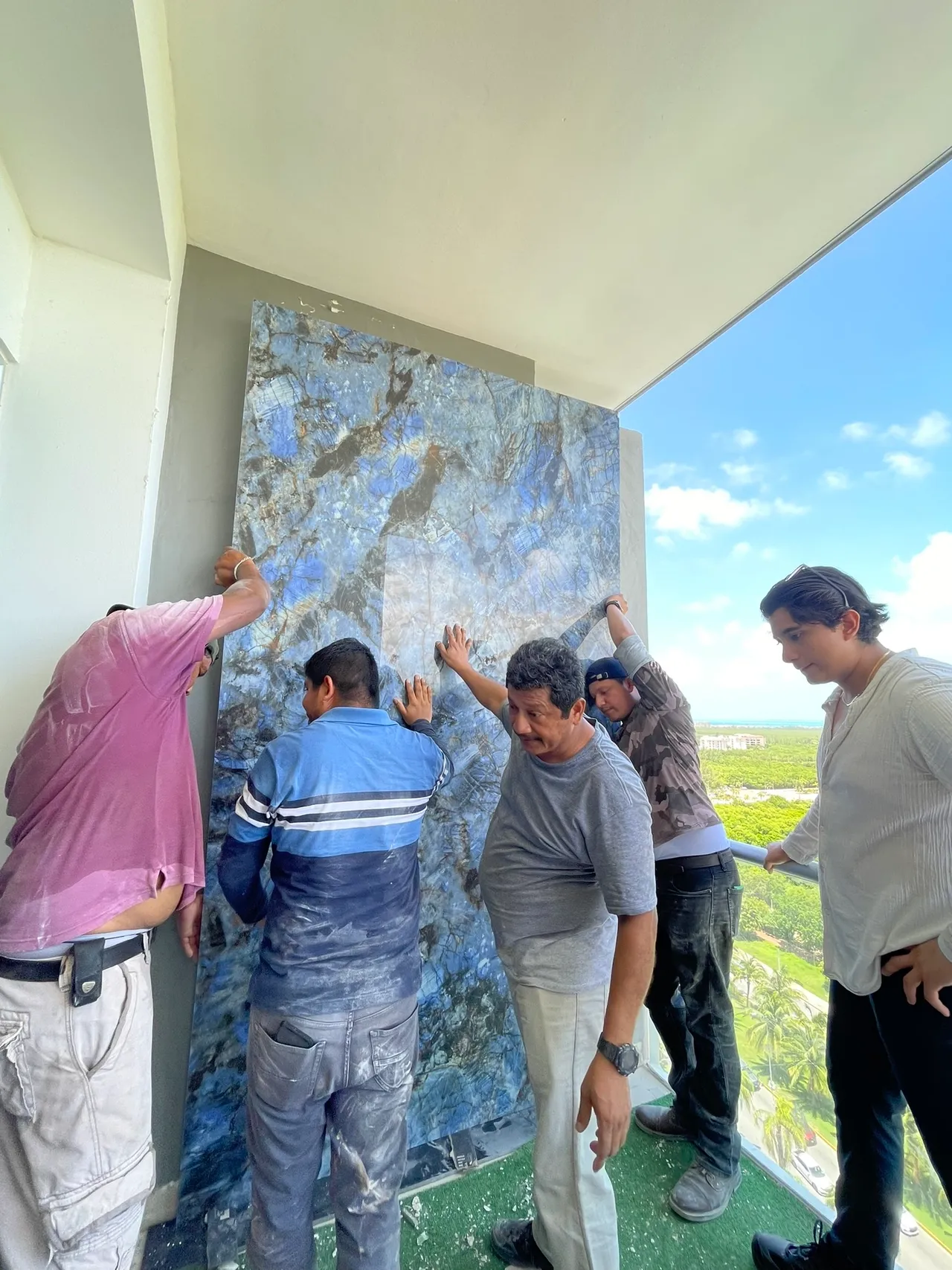 Instalación de una gran placa azul de piedra sinterizada en muro exterior