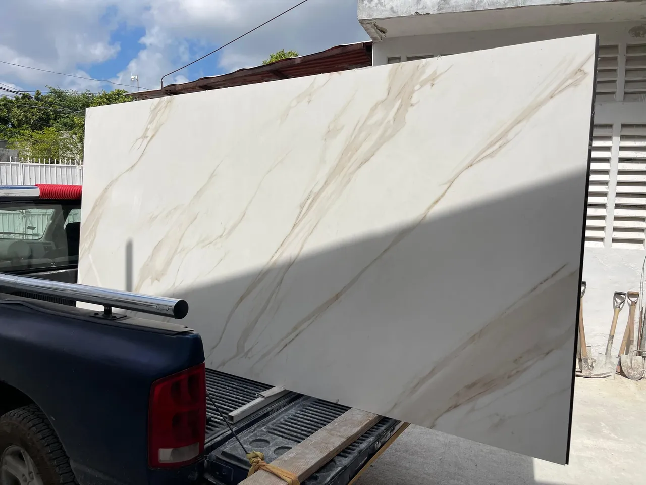 Losa de piedra sinterizada modelo mármol blanco con vetas doradas durante el transporte