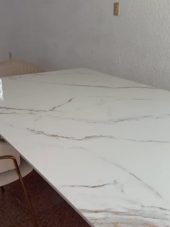 Detalle de la superficie de piedra sinterizada con vetas grises y oro sutiles