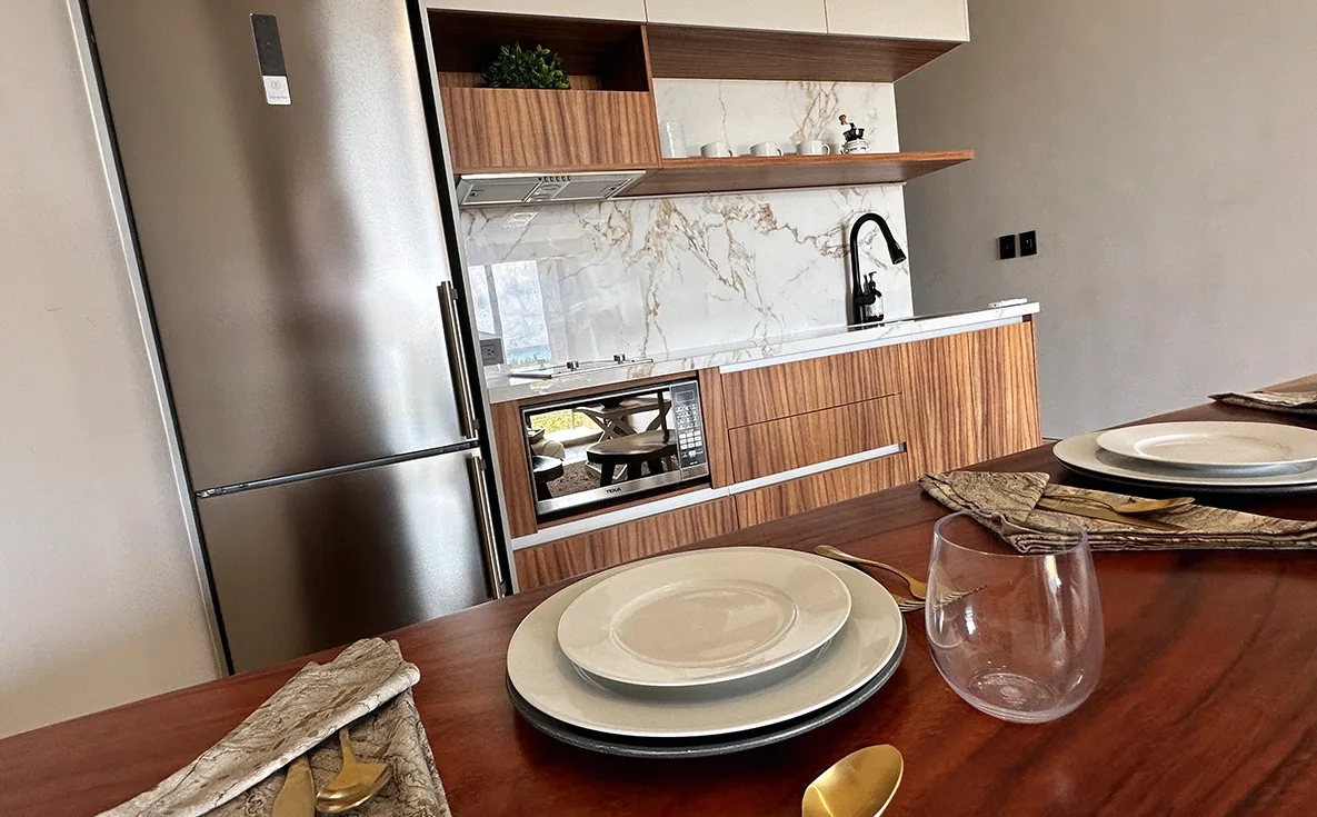 Detalle de cocina con respaldo y cubierta en piedra sinterizada en el proyecto IXUH