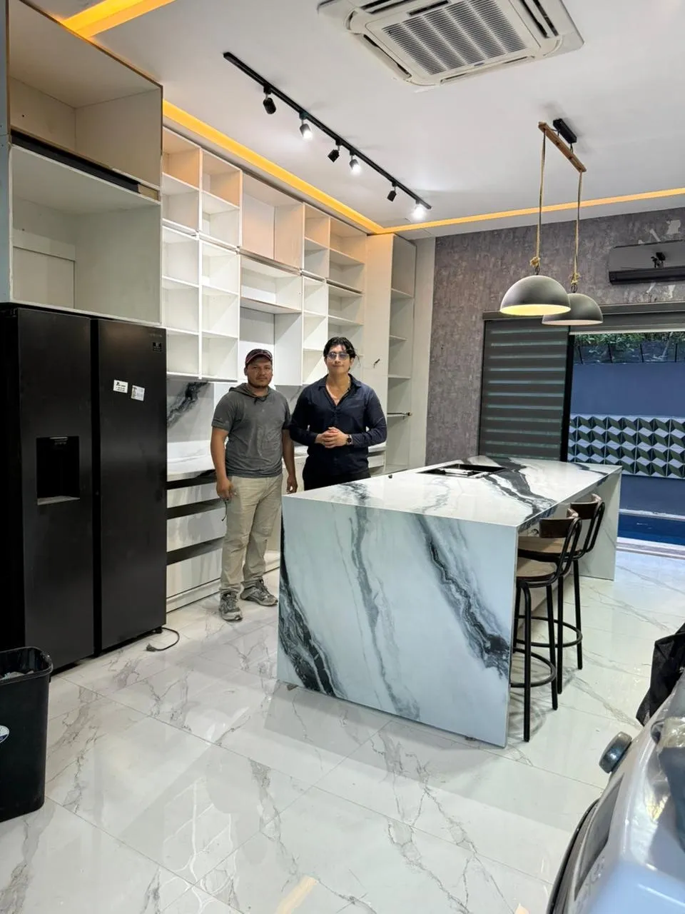 Equipo de D-Stone junto a la cocina terminada en Panda White
